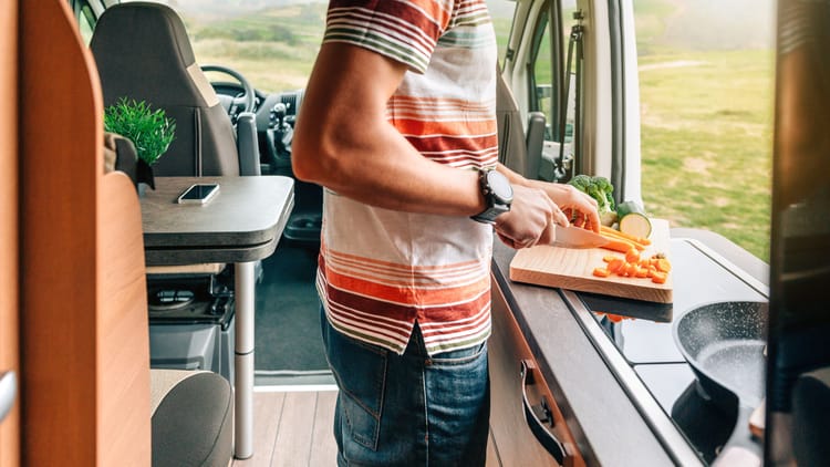 A man cutting vegetables with his RV kitchen essentials